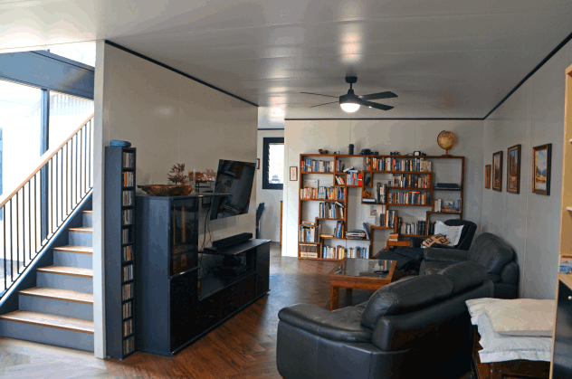 A MAAP Modular living area with comfortable furnishings, a Ceiling Fan, Stairs and Sofas