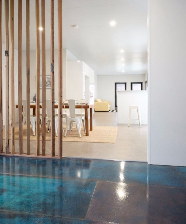 Internal view of a MAAP House showing a custom timber dividing screen and textured paint on the entry floor