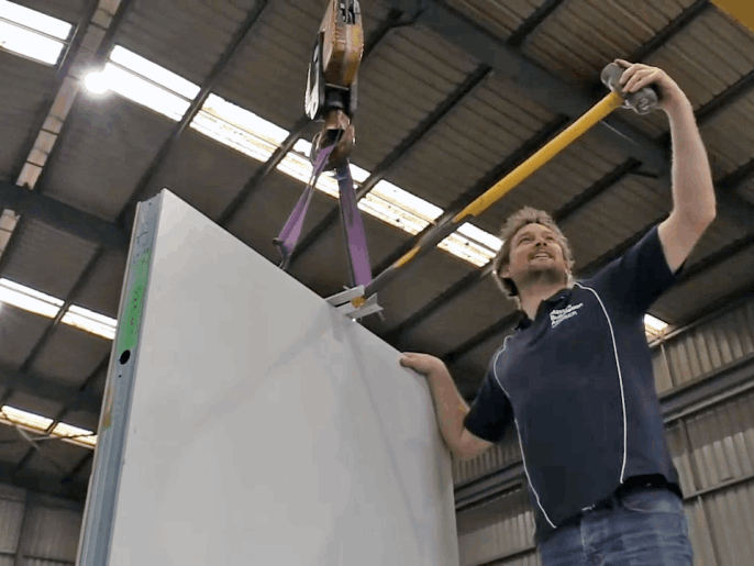 MAAP worker lines up sledge hammer to test strength of standard MAAP Wall Panel