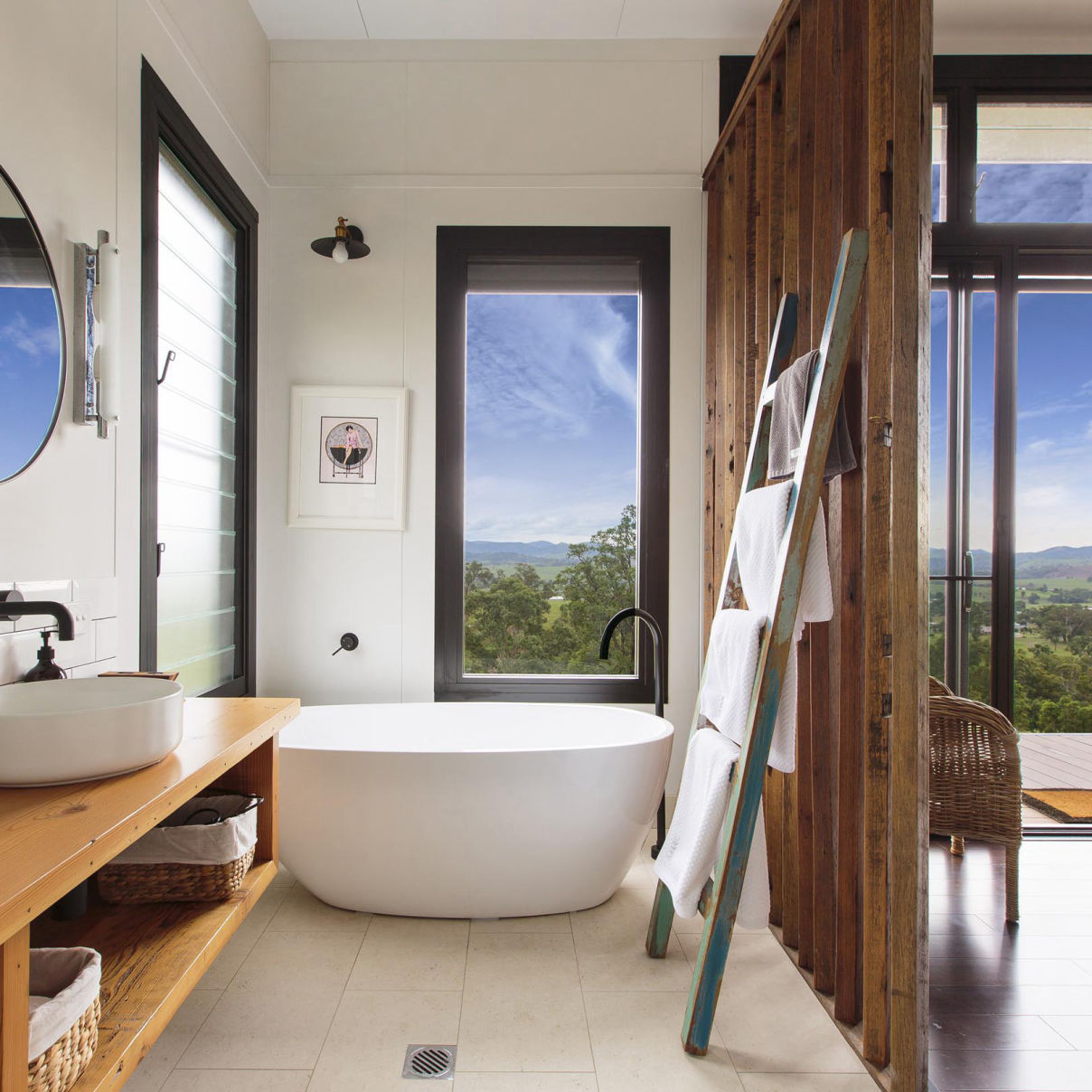 This MAAP House bathroom contains a freestanding bathtub with feature timber screen and recycled towel ladder