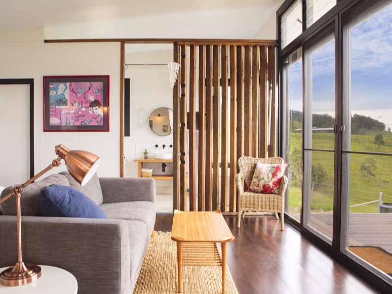 A MAAP House lounge area looks out over the deck to verdent countryside with peace and tranquility